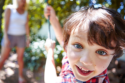 Buy stock photo Cropped shot of a young boy swinging in the yard