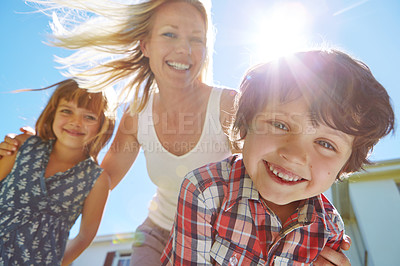 Buy stock photo Shot of a happy family of three enjoying a sunny day in their backyard