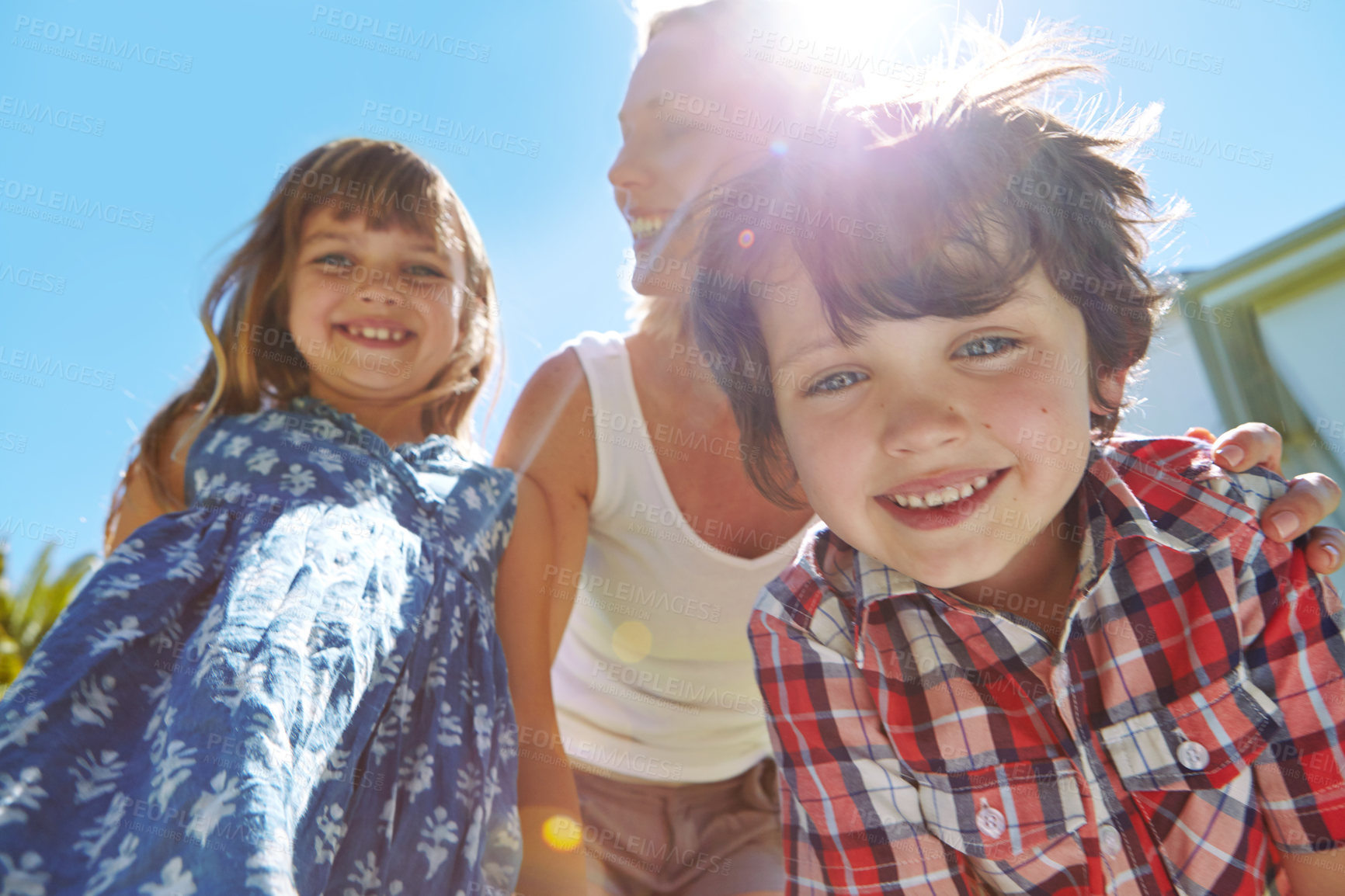 Buy stock photo Shot of a happy family of three enjoying a sunny day in their backyard