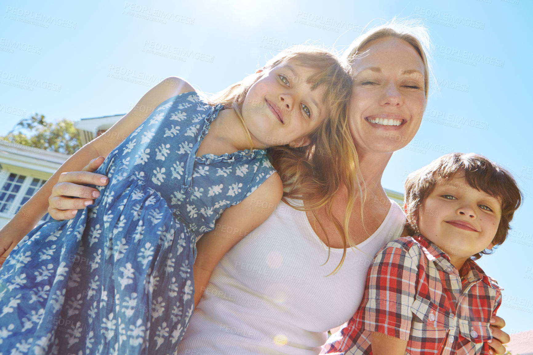 Buy stock photo Shot of a happy family of three enjoying a sunny day in their backyard