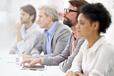 Buy stock photo Shot of a group of dedicated business professionals sitting in a row