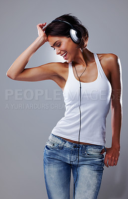 Buy stock photo Woman, music and fun with confidence, laughing and excited with smile and casual fashion in studio. Young, portrait and happy with audio and joy with grey background and freedom from party song