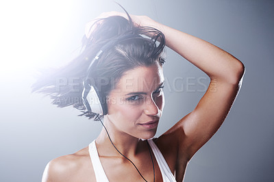 Buy stock photo Woman, music and portrait with dancing and confidence with headphones and smile in studio. Young student, freedom and face with wild hair and joy with grey background and carefree from party song