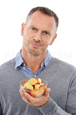 Buy stock photo Portrait, fruit salad and unhappy with a mature man in studio isolated on a white background for health eating. Face, food and upset with an annoyed male on blank space feeling negative about a diet