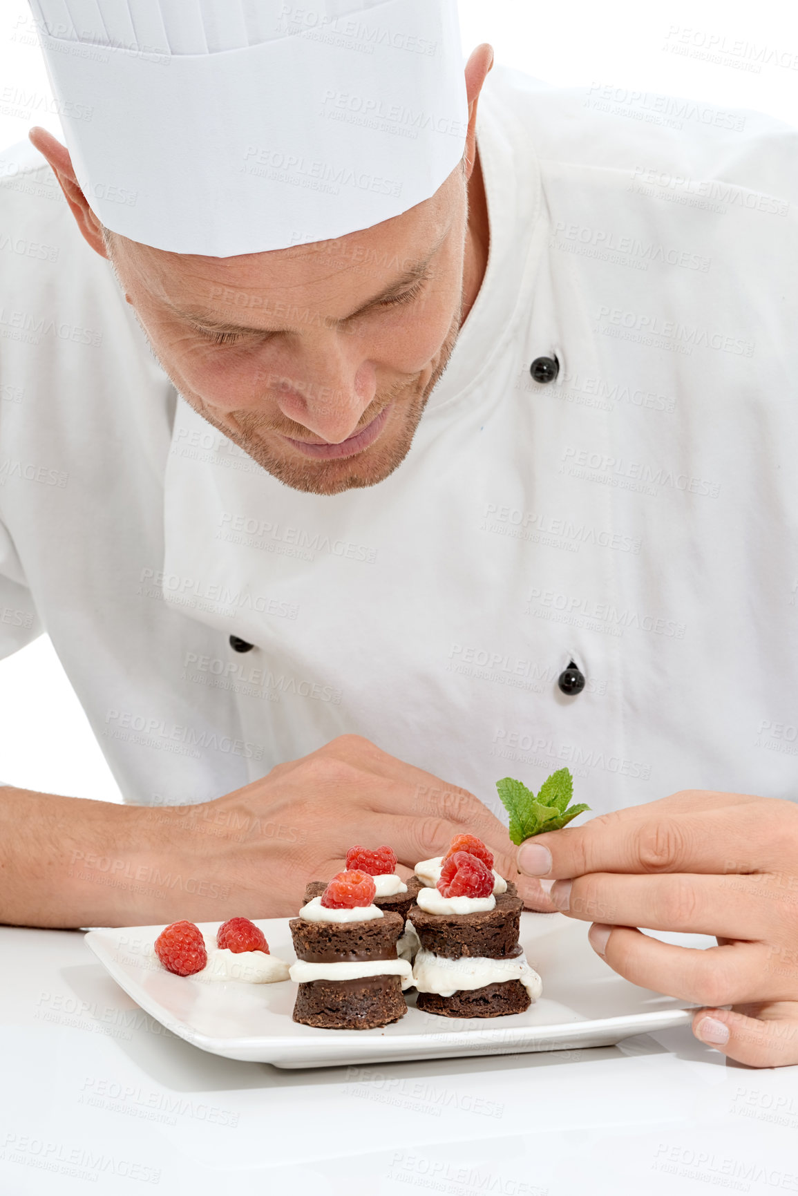 Buy stock photo Chef, dessert and mint on sweet food by culinary cook with chocolate recipe on a plate isolated in white studio background. Cooking, presentation and man making mini cakes as cuisine for fine dining