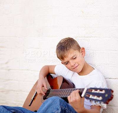 Buy stock photo Boy, guitar and smile for music practice, talent development or learning skill lesson. Male person, school child or white wall background or string acoustic instrument hobby or band, playing or rock