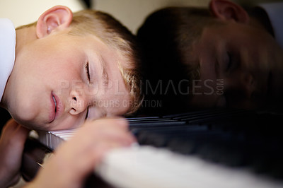 Buy stock photo Young, child or sleep on piano or music keys for skill development tired, class lesson or rest. Male person, boy or relax on instrument for performance practice, talent discipline or concert learning