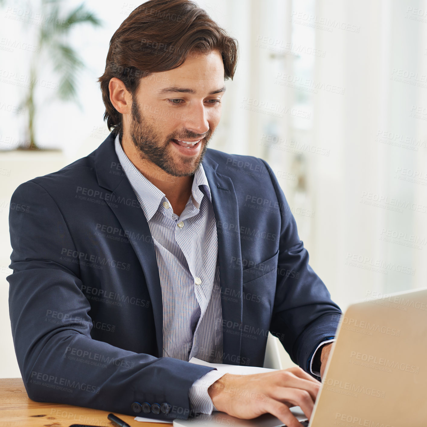 Buy stock photo A handsome businessman working on his laptop