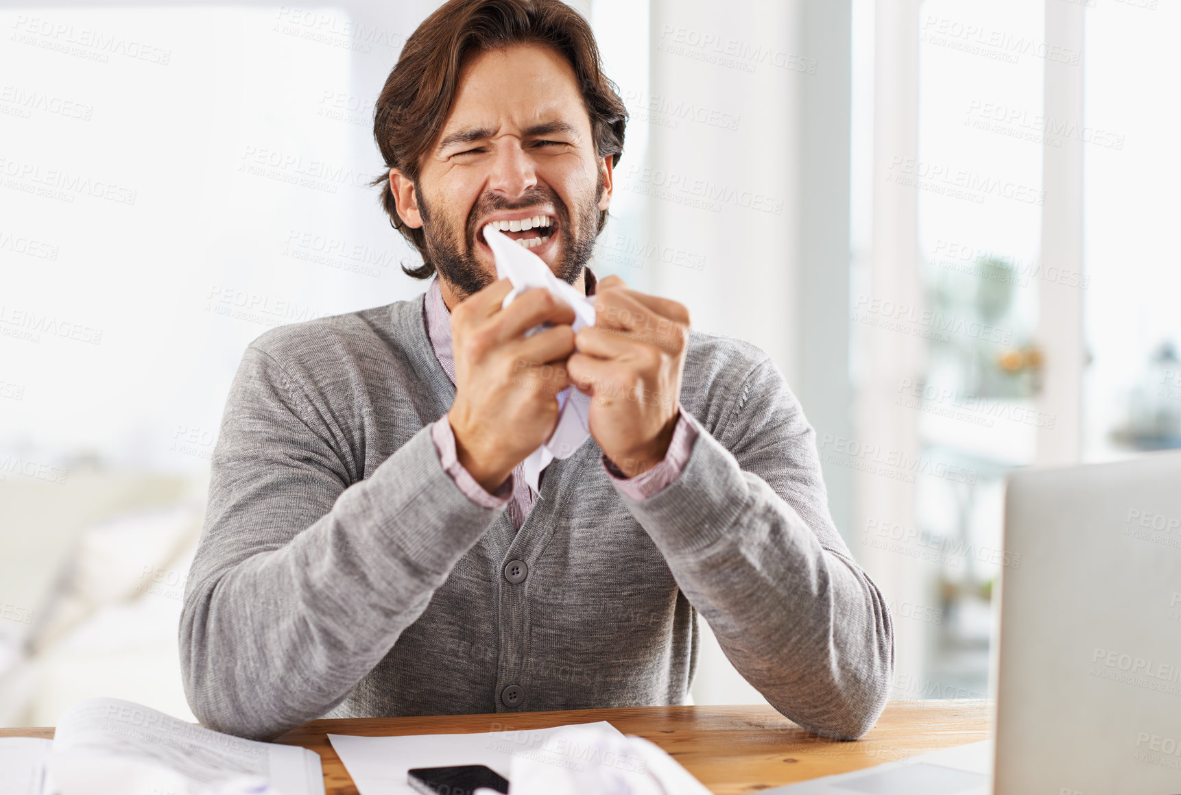 Buy stock photo A handsome businessman crumpling paper in frustration over work stress