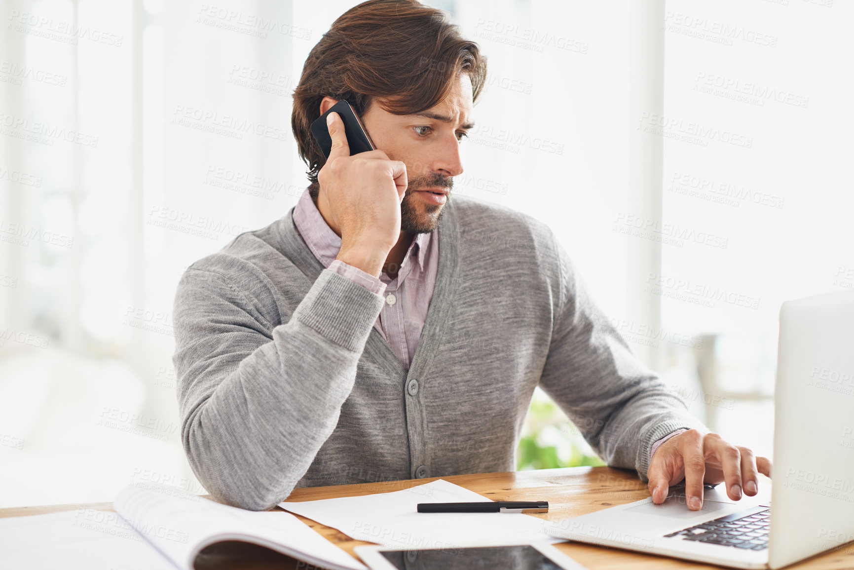 Buy stock photo A handsome businessman speaking on his mobile at his desk