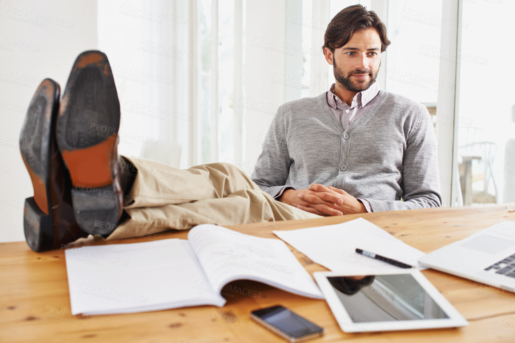 Buy stock photo A handsome businessman relaxing at his desk