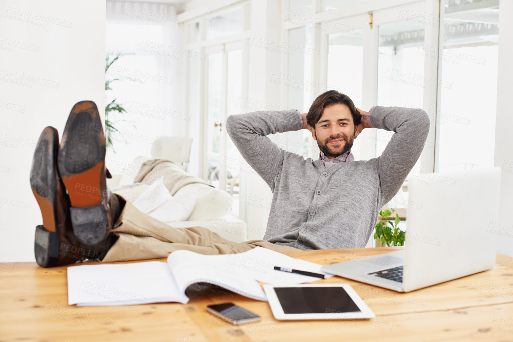 Buy stock photo Businessman, relax and smile with computer at house for remote, freelance work and internet research. Male person, hands and feet on desk for wellness and technology in home office for online job