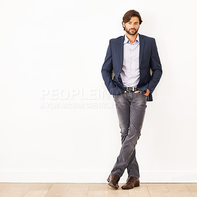Buy stock photo Portrait of a confident young businessman leaning against a white wall