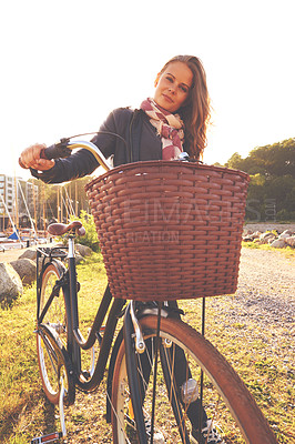 Buy stock photo Portrait, flare and a girl with her bicycle in the park for travel, freedom or eco friendly adventure. Summer, cycling and a young person outdoor in the countryside for a cycling ride with a basket