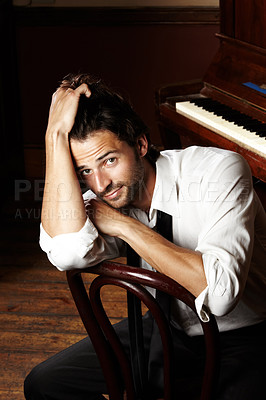 Buy stock photo Portrait of a young musician sitting in front of his piano