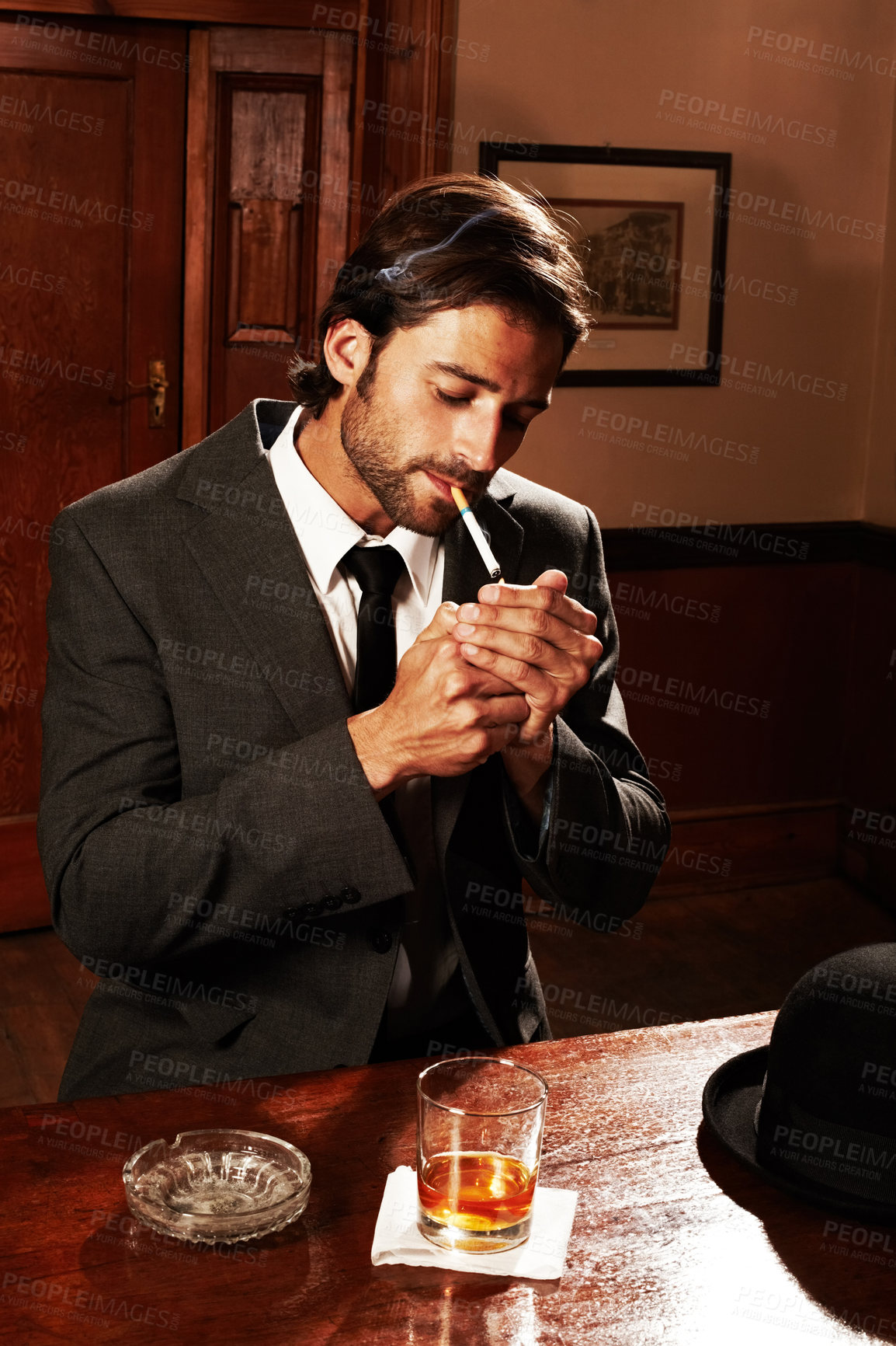 Buy stock photo Pub, smoking and man with a cigarette, whiskey and stylish outfit with gentlemen, unhealthy habit or fashion. Person, guy or smoker with ashtray, tavern or pub with suit, tobacco or luxury with glass