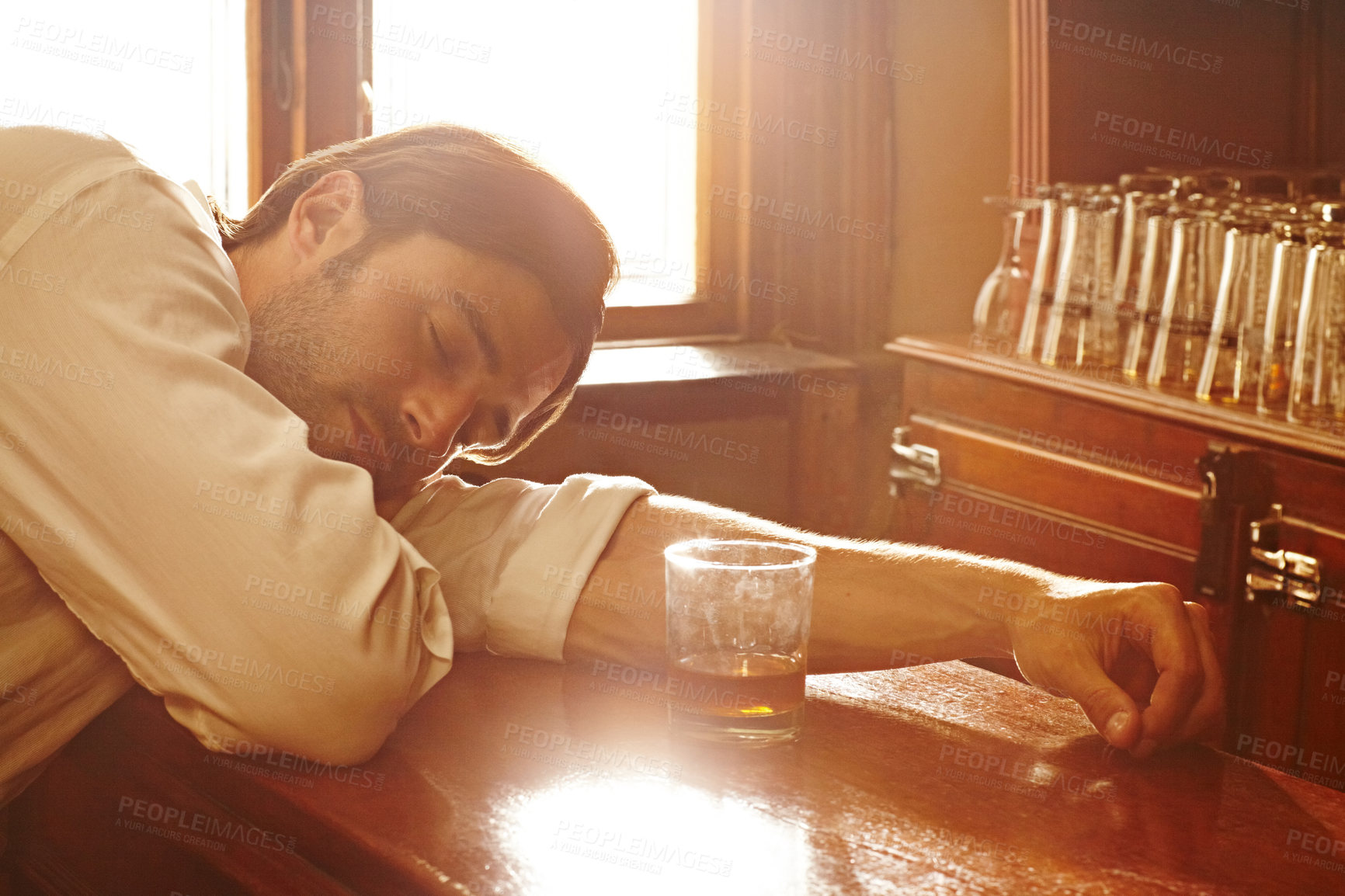 Buy stock photo Sleeping, counter and man with whiskey, alcoholic and unhealthy habit with depression, tired and overworked. Person, addict and guy with a drink, exhausted and drunk with handover, brandy and booze