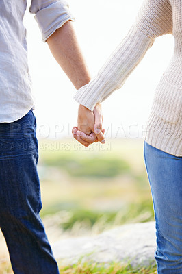 Buy stock photo Holding hands, closeup and couple on holiday at beach with love, trust and support on journey together. Marriage, man and woman in nature, walking with care and respect for partnership or bonding