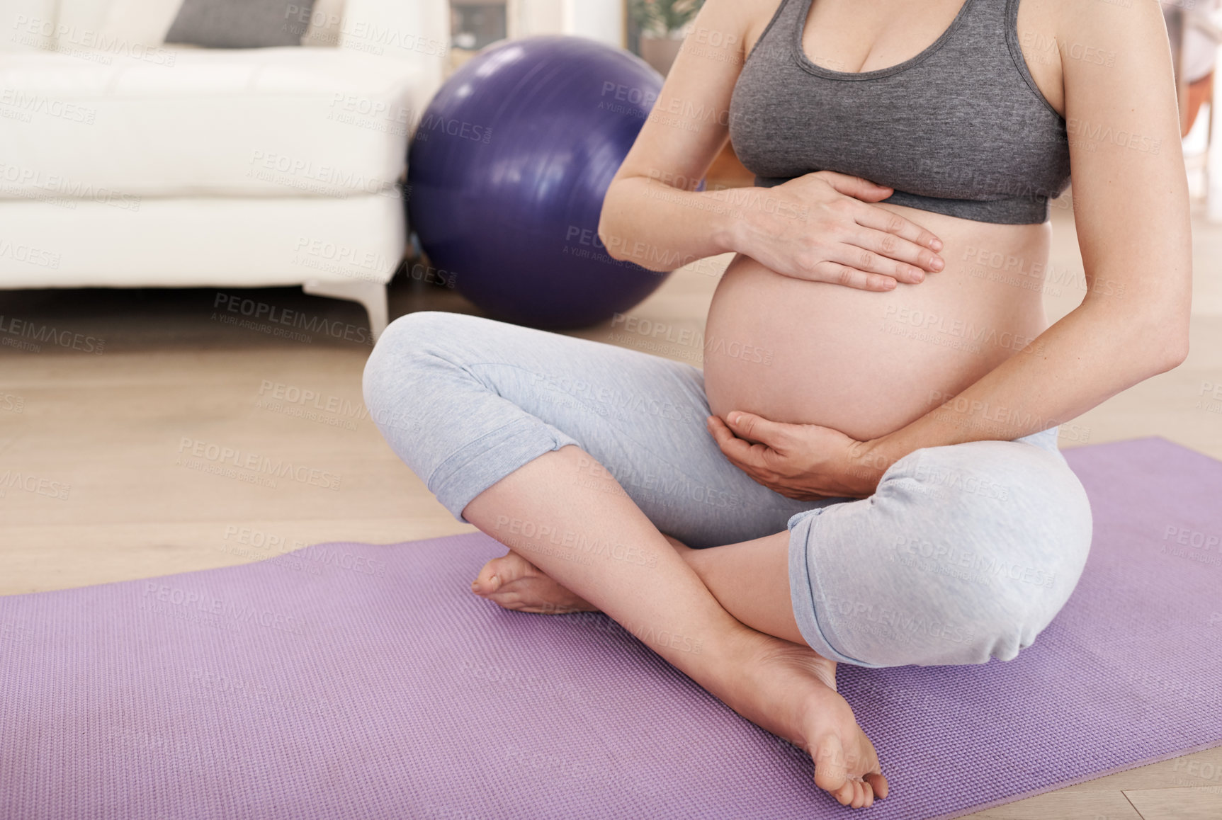 Buy stock photo Cropped shot of a pregnant woman exercising at home