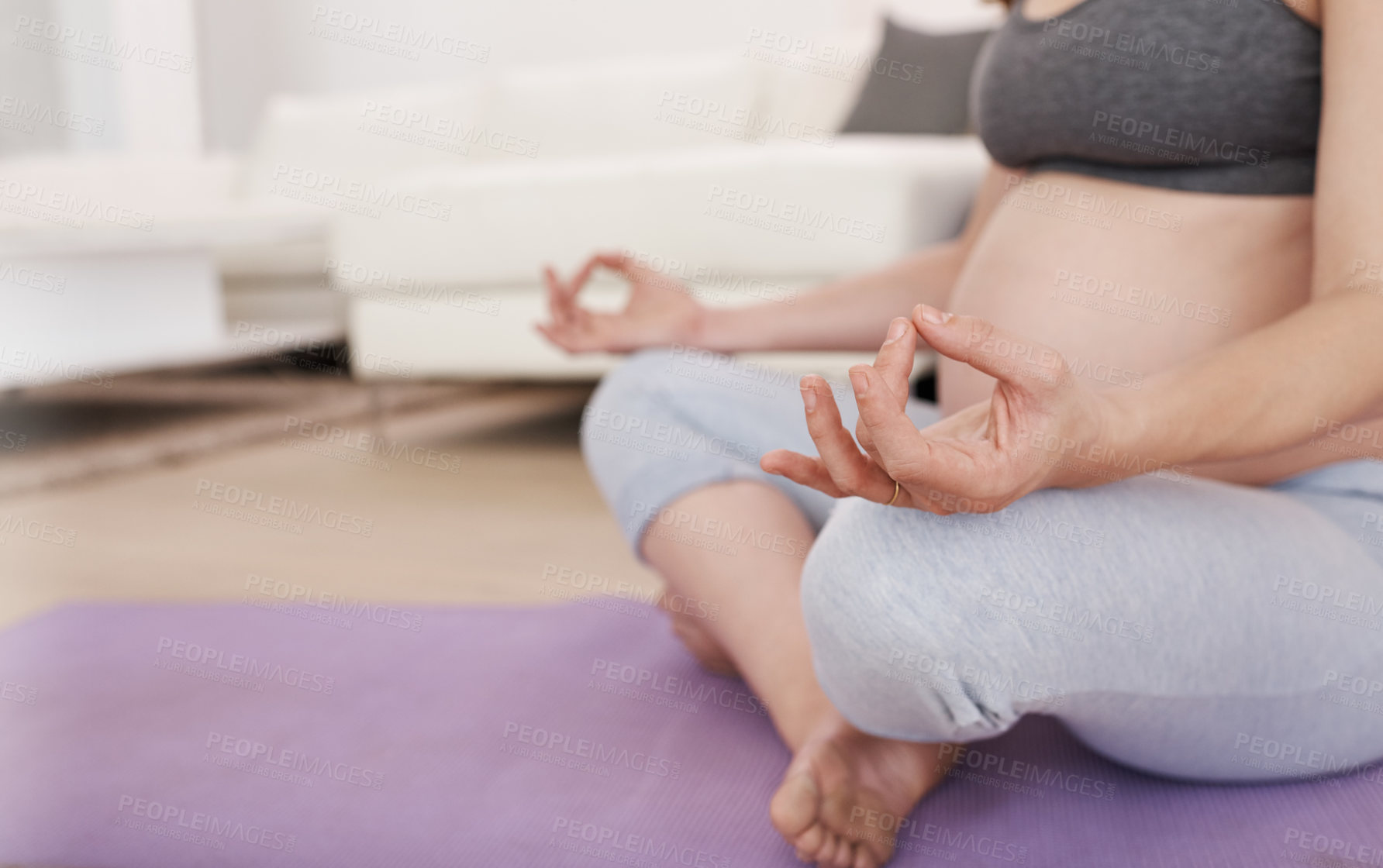 Buy stock photo Cropped shot of a pregnant woman meditating at home