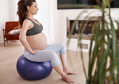 Buy stock photo Shot of a young pregnant woman exercising at home