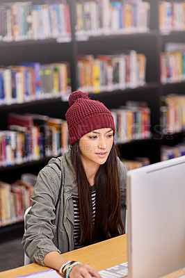 Buy stock photo Shot of a female student working on a computer in a university library