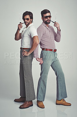 Buy stock photo Studio shot of two men standing together while wearing retro 70s wear and striking a pose