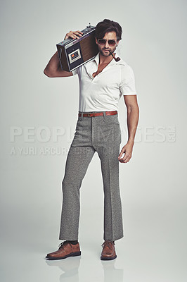 Buy stock photo A studio shot of a handsome man in retro 70s wear holding a cassette player