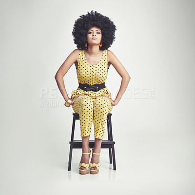 Buy stock photo A young woman wearing a 70s retro jumpsuit while in the studio