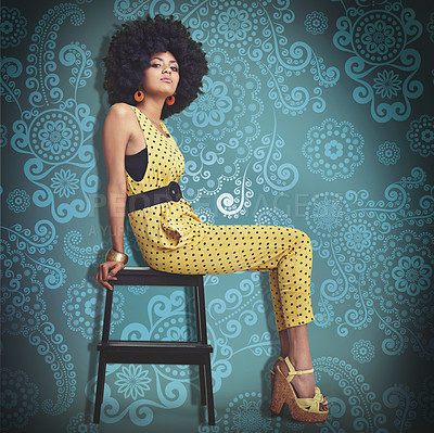 Buy stock photo Portrait, young woman and fashion in 70s retro colour jumpsuit and sitting on chair. African trend, elegant model pretty in vintage outfit, big curly hair and wedge heels on cool pattern background
