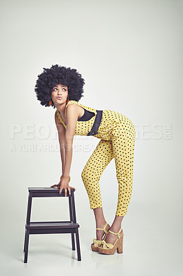 Buy stock photo A young woman wearing a 70s retro jumpsuit while pouting and striking a pose
