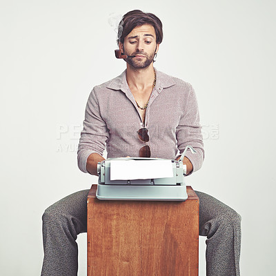 Buy stock photo A young man in 70s style clothing using a typewriter