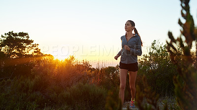 Buy stock photo Shot of a young woman jogging outdoors