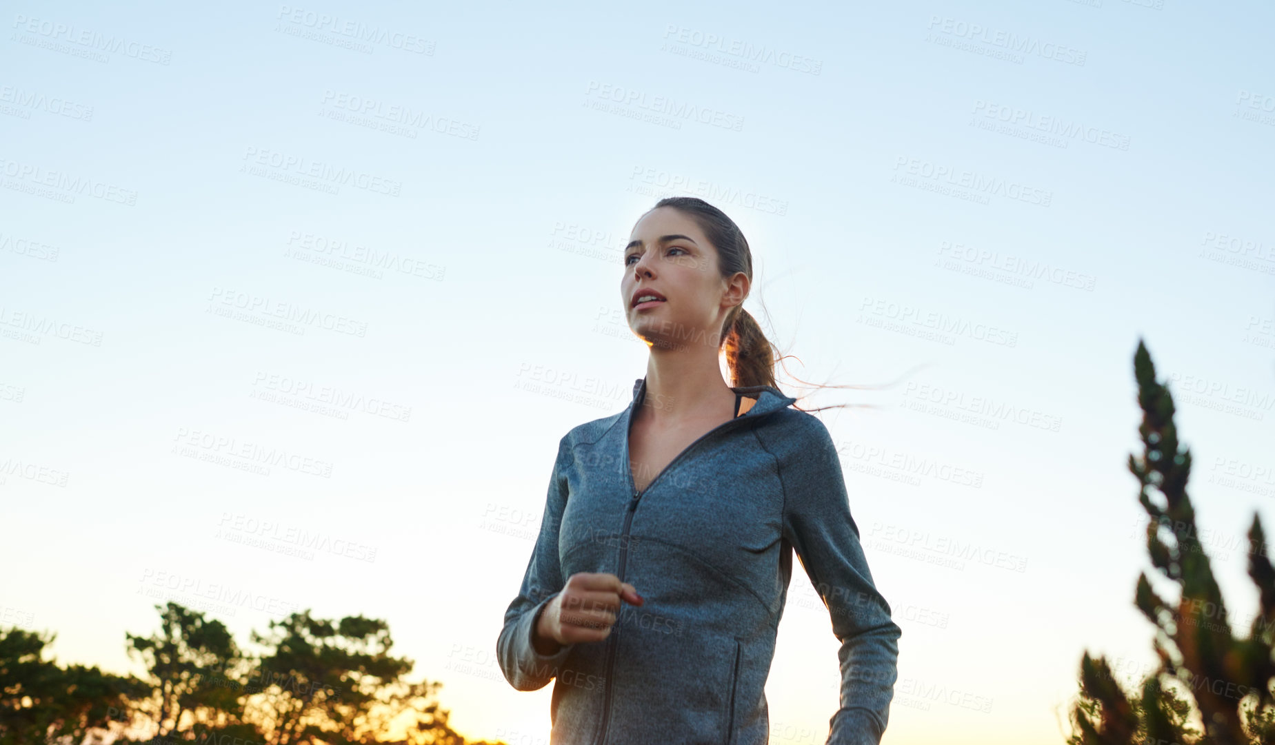 Buy stock photo Sky, woman and running in forest for fitness on road for exercise, training and workout. Endurance runner, nature and female athlete in outdoor sports for practice for wellness and health in woods