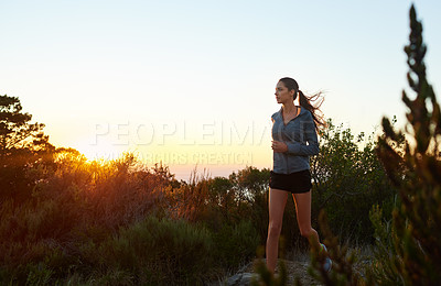Buy stock photo Shot of a young woman jogging outdoors