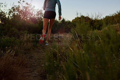 Buy stock photo Low angle shot of a young woman running outdoors