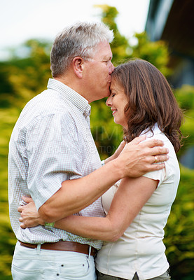 Buy stock photo Senior man, kissing and woman on forehead in backyard, care or couple love for commitment in marriage. France, husband or wife in garden to connect, hug or happy together in support or relax partner