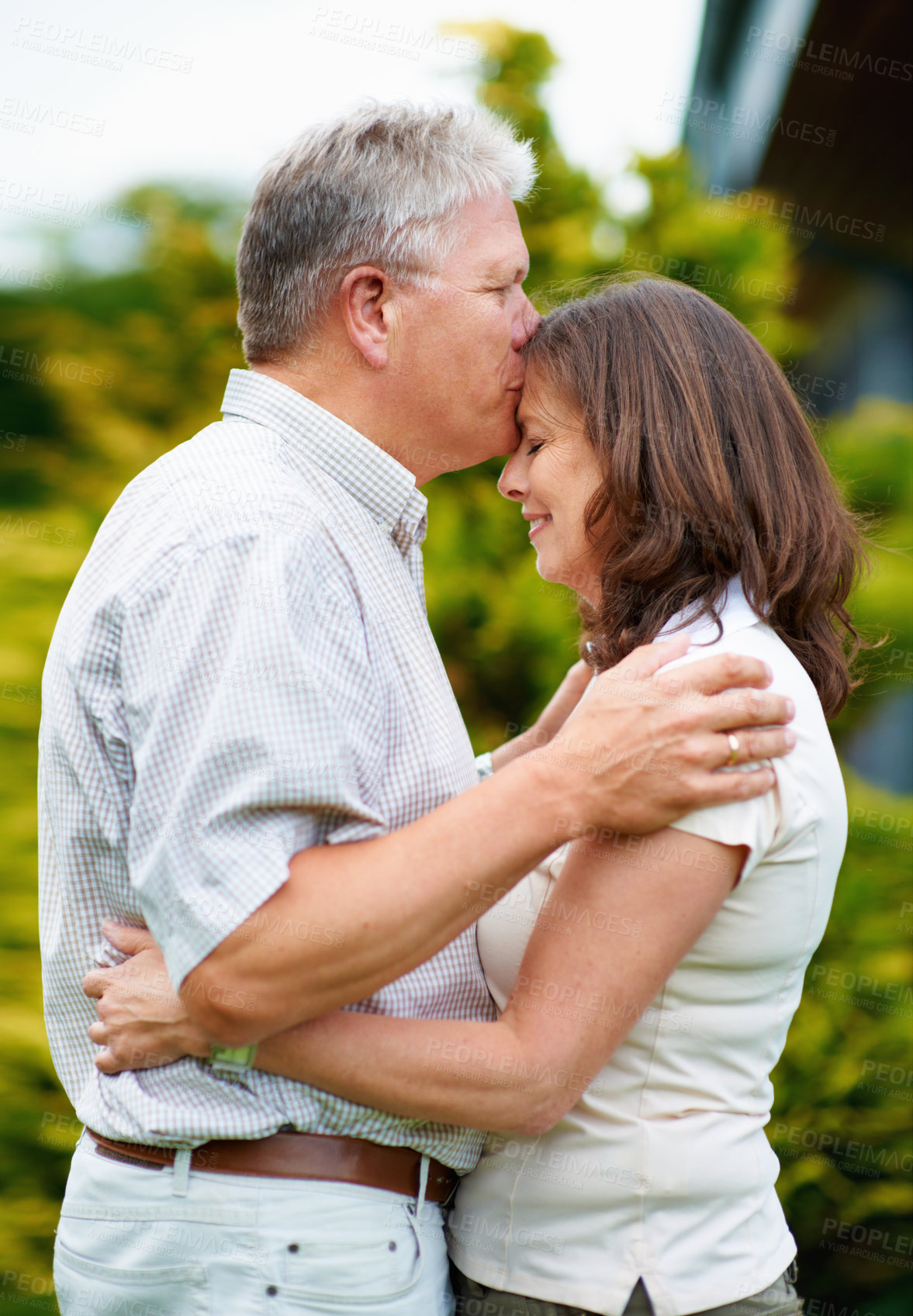 Buy stock photo Senior man, kissing and woman on forehead in backyard, care or couple love for commitment in marriage. France, husband or wife in garden to connect, hug or happy together in support or relax partner