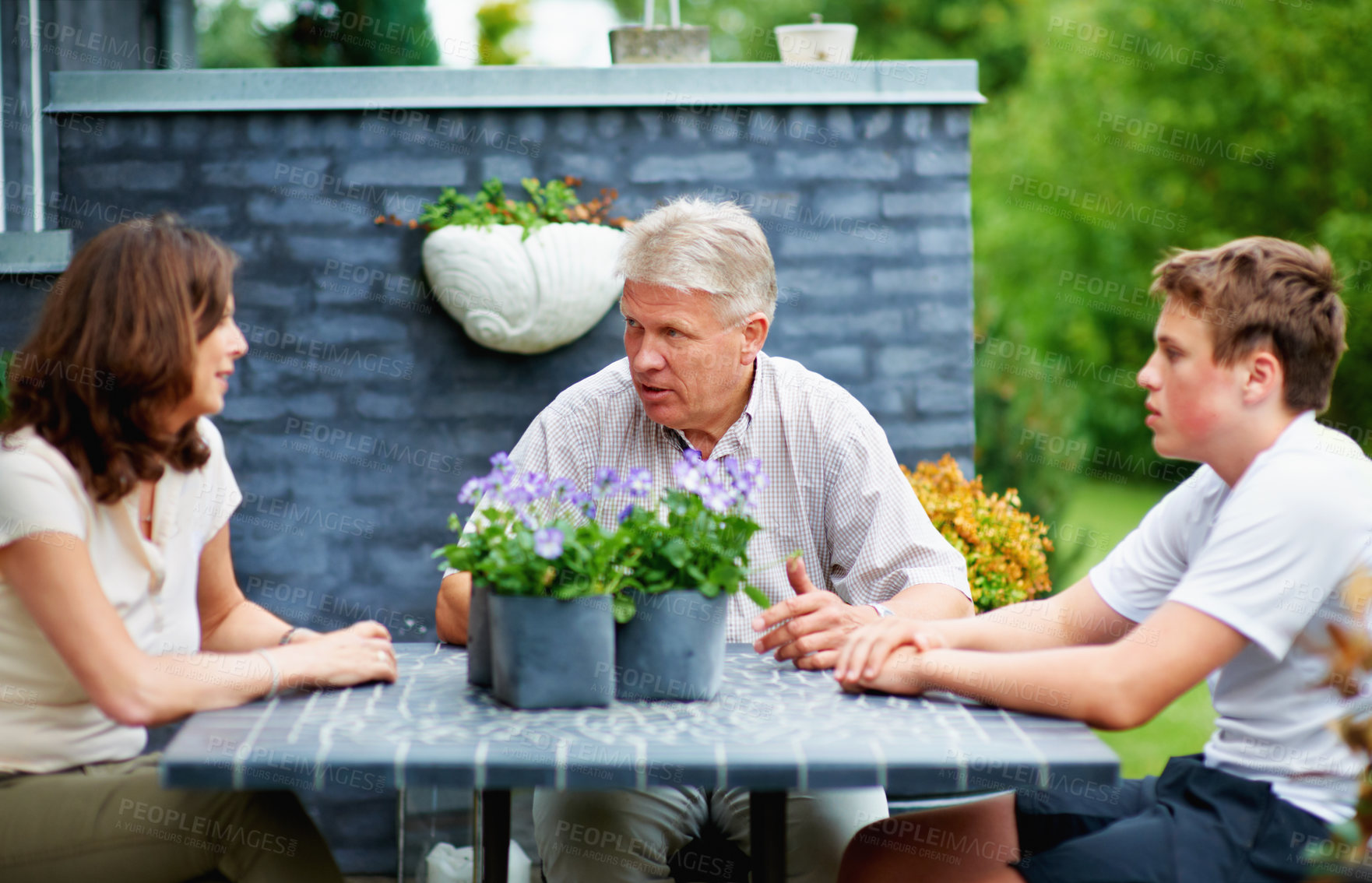 Buy stock photo Cropped shot of a senior couple sitting outside with their grandson