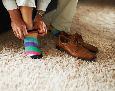 Buy stock photo Cropped shot of a man putting on colourful socks and loafers