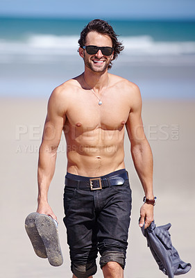Buy stock photo Portrait, smile and the body of a man on the beach for travel, freedom or adventure on vacation. Sunglasses, sand and a young person walking shirtless by the ocean or sea on the coast for a holiday