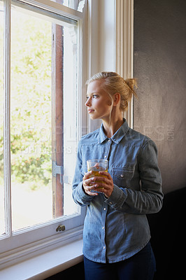 Buy stock photo Woman, tea and thinking at window in home for herbal detox or healthy drink with leaves, relax or morning. Female person, glass and thoughts for wellness benefits or apartment, beverage or breakfast