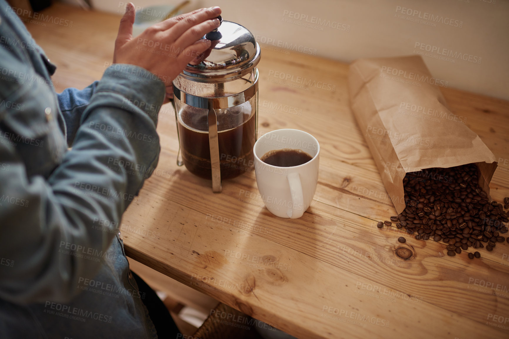 Buy stock photo Cropped shot of female person making hot drink from coffee kettle for warmth indoors. High angle view of a woman preparing black coffee using modern coffee machine, and standing at home in kitchen  