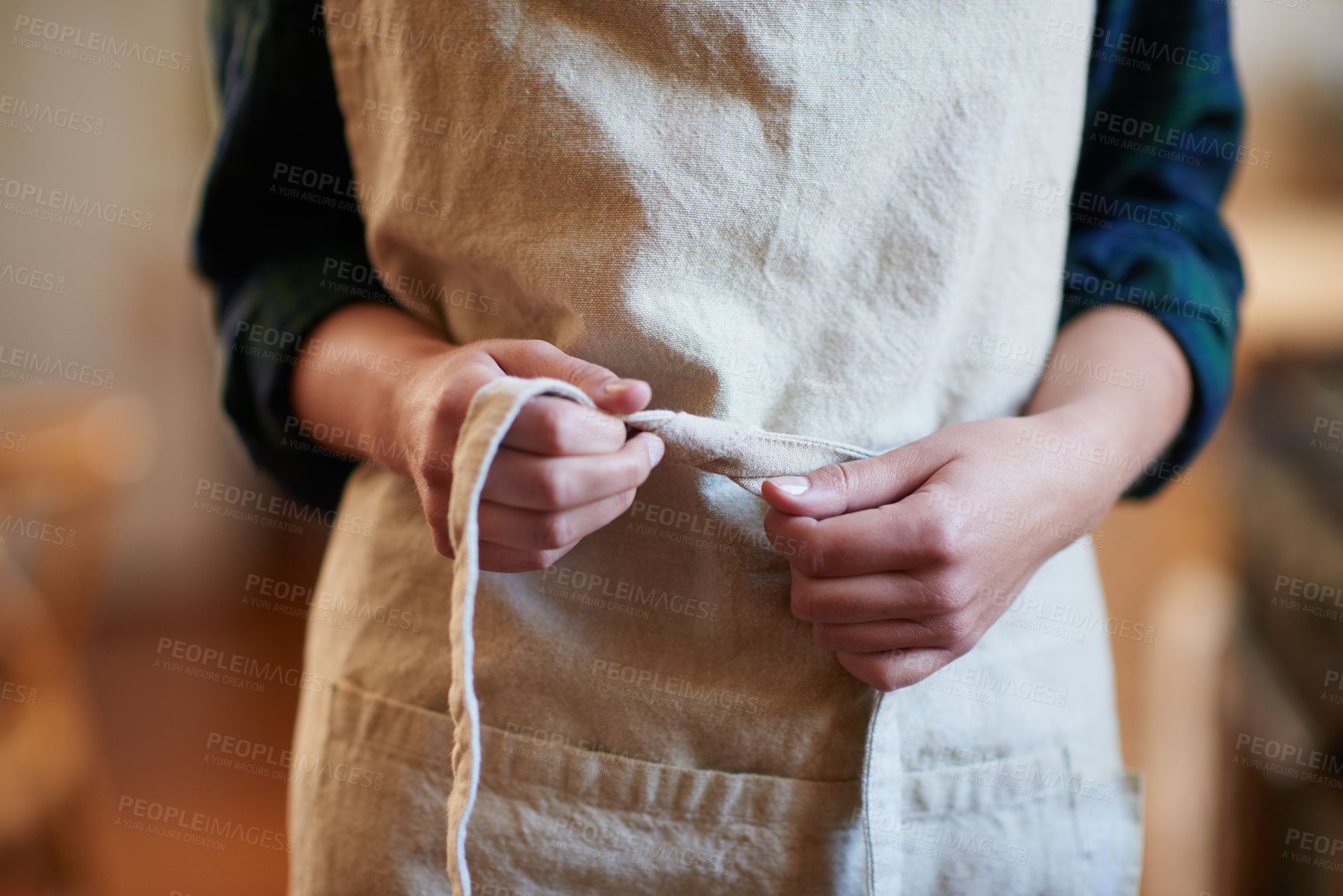 Buy stock photo A young woman wearing an apron