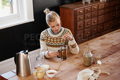 Buy stock photo Woman, herbal tea and prepare with leaves at kitchen table with french press or kettle for health, beverage or detox. Female person, plunger and relax morning for breakfast drink, vacation or home