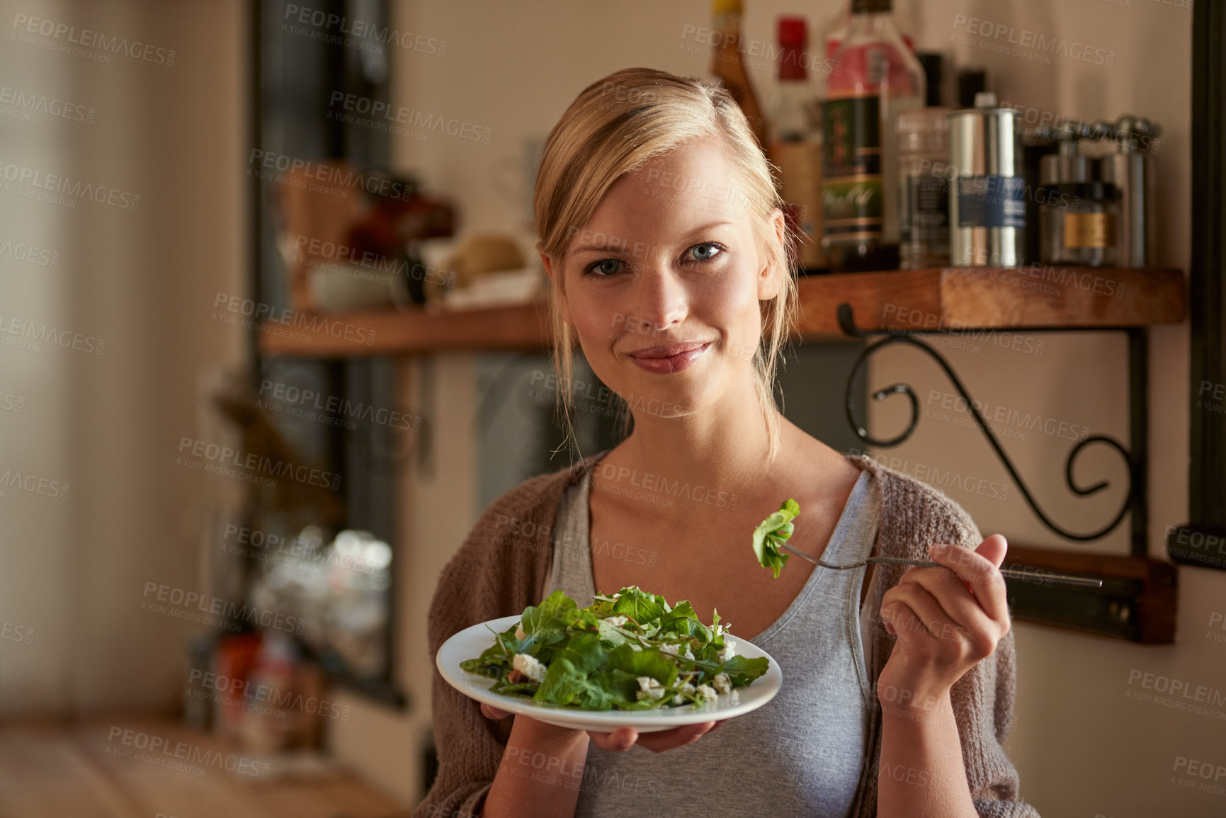 Buy stock photo Portrait, woman and eating salad in kitchen at home, nutrition and fresh leafy greens for healthy diet. Vegetables, bowl and face of hungry person with food, fork and organic vegan meal for wellness