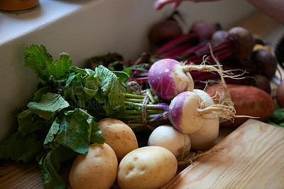 Buy stock photo Root, vegetables and ingredients on kitchen counter for cooking recipe or leafy greens, radish or potato. Wood board, food and diet in apartment for healthy wellness or vegan eating, fibre or meal