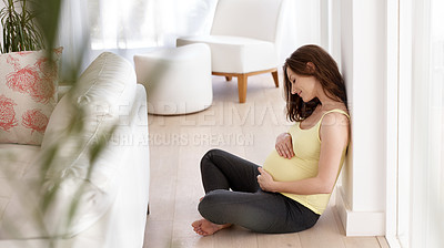 Buy stock photo Shot of a young pregnant woman in her living room