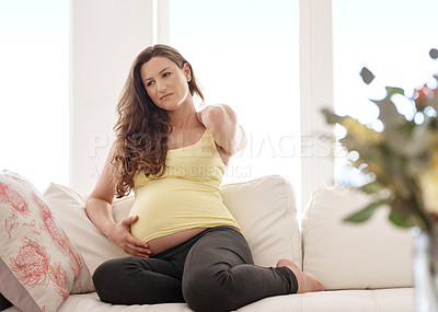 Buy stock photo Shot of a young pregnant woman rubbing her neck