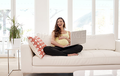 Buy stock photo Shot of a young pregnant woman working on her laptop at home